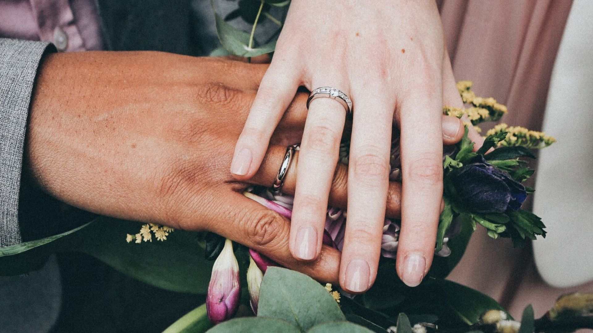 couples wearing rings and holding flowers